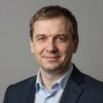 Улыбающийся российский бизнесмен с белоснежной улыбкой на нейтральном фоне для сайта отбеливания зубов