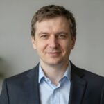 Портрет уверенного российского бизнесмена с белоснежной улыбкой на нейтральном фоне для сайта отбеливания зубов